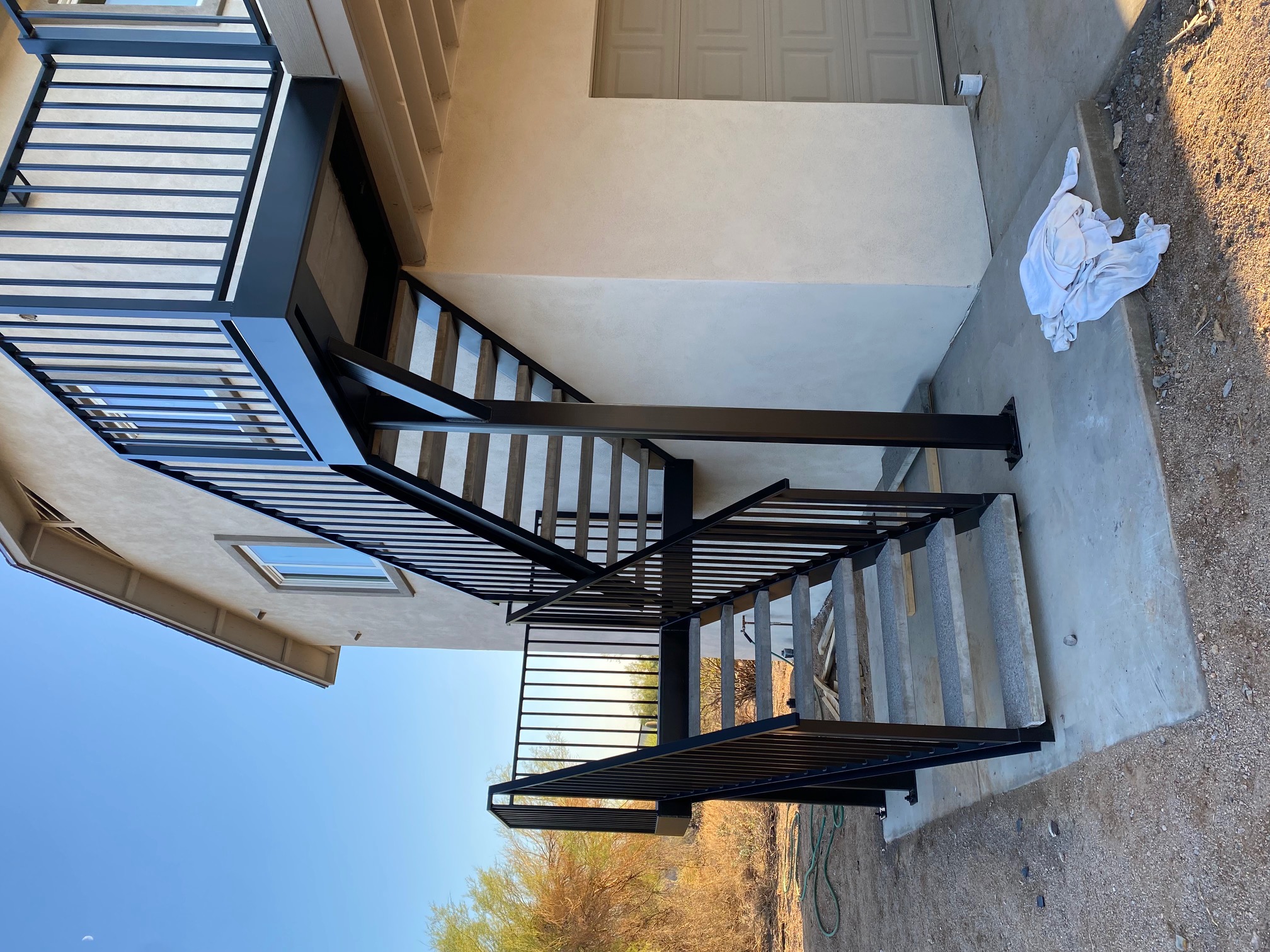 Exterior black steel staircase with vertical bar railings